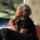 a middle aged woman looking afar while sitting on couch
