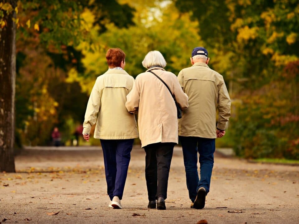 three elderly people walking together