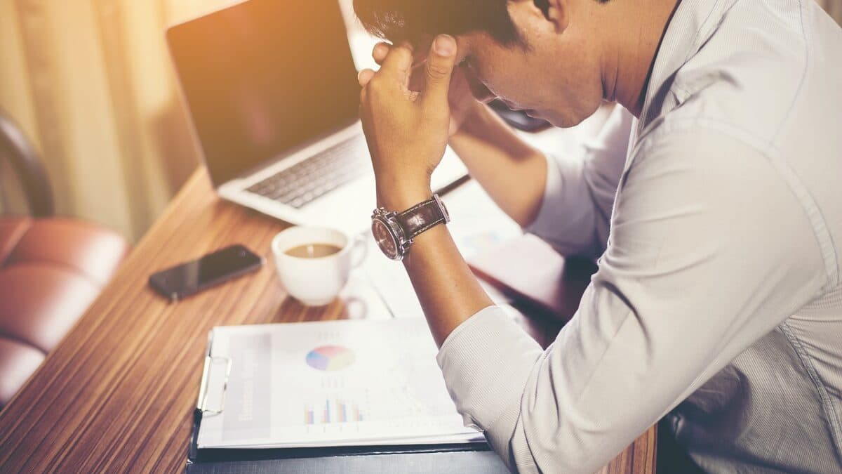 a stressed man looking at his work