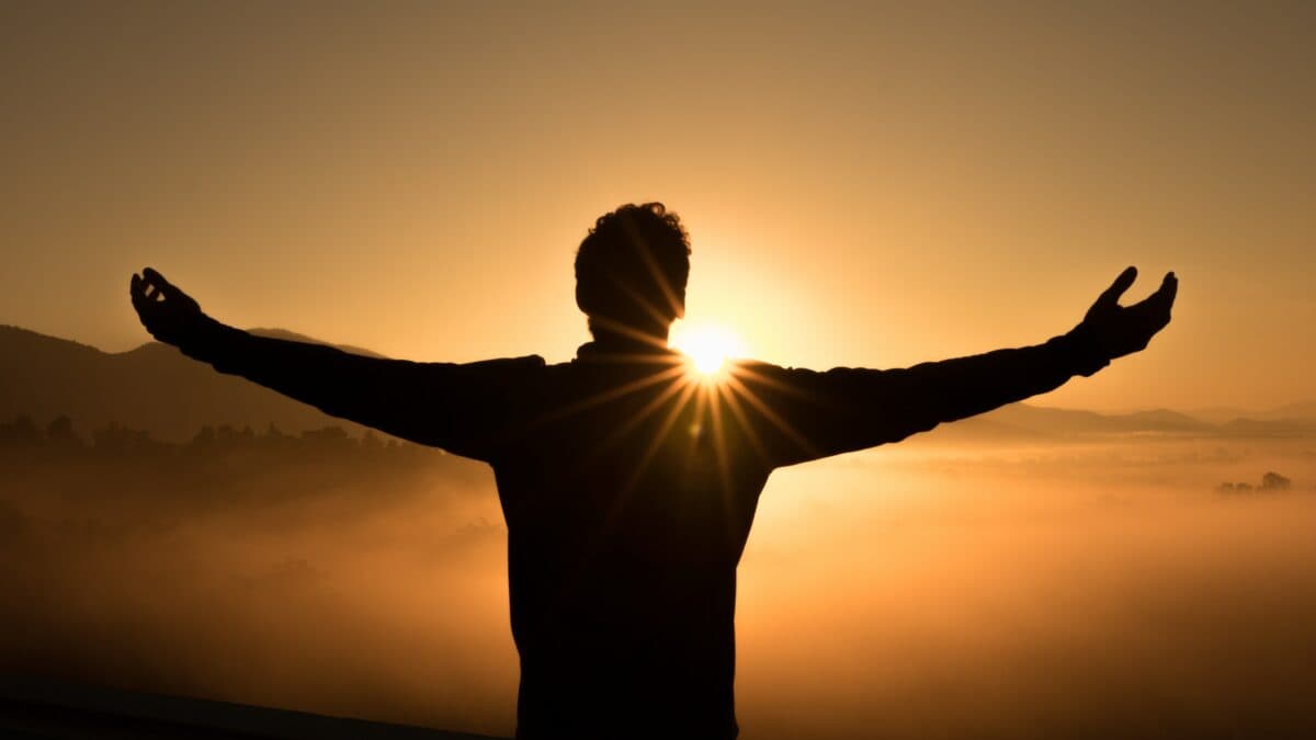 person facing the sunset in a foggy mountain