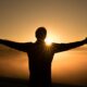person facing the sunset in a foggy mountain