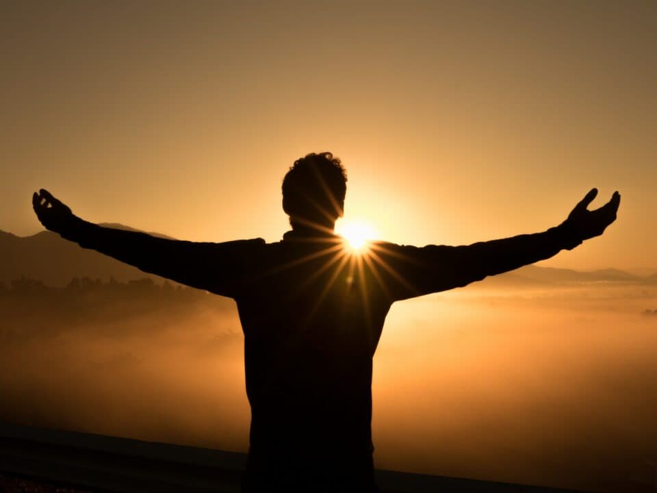 person facing the sunset in a foggy mountain