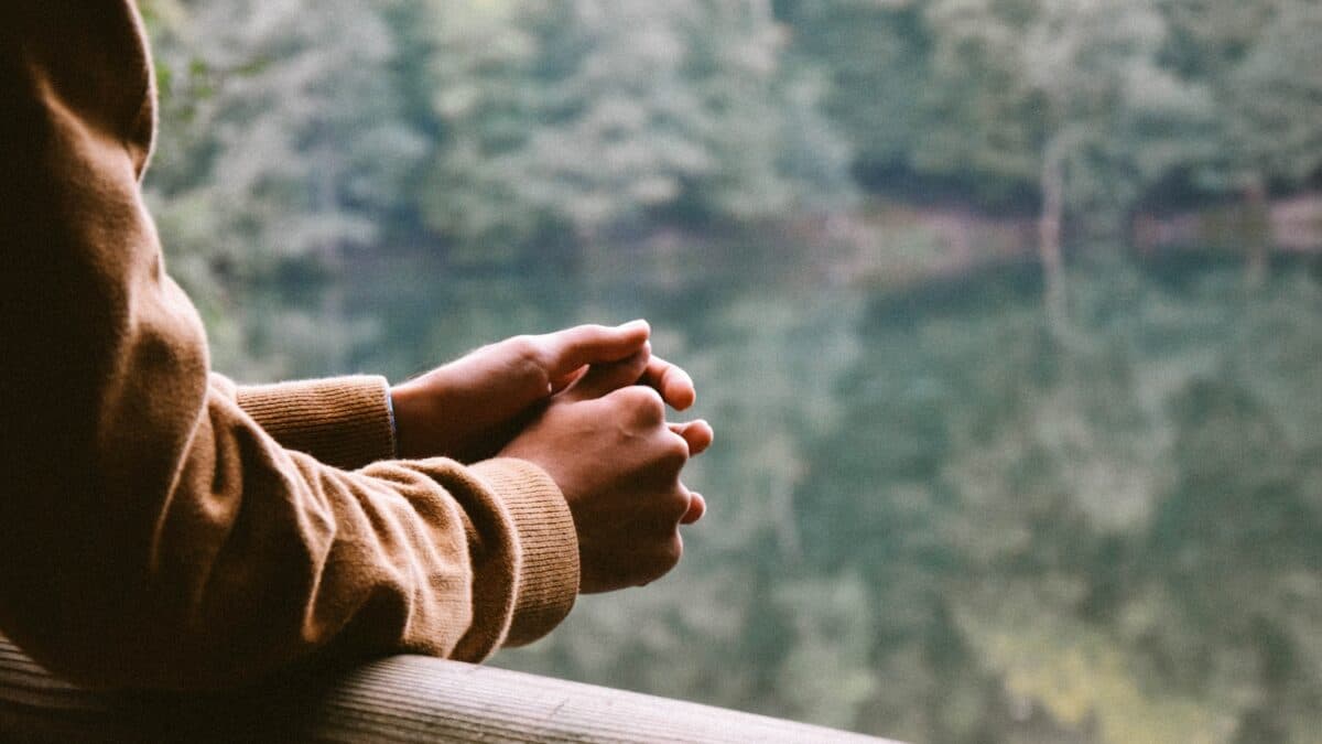 a person resting on a balcony holding both hands