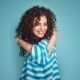 girl with curly hair hugging herself