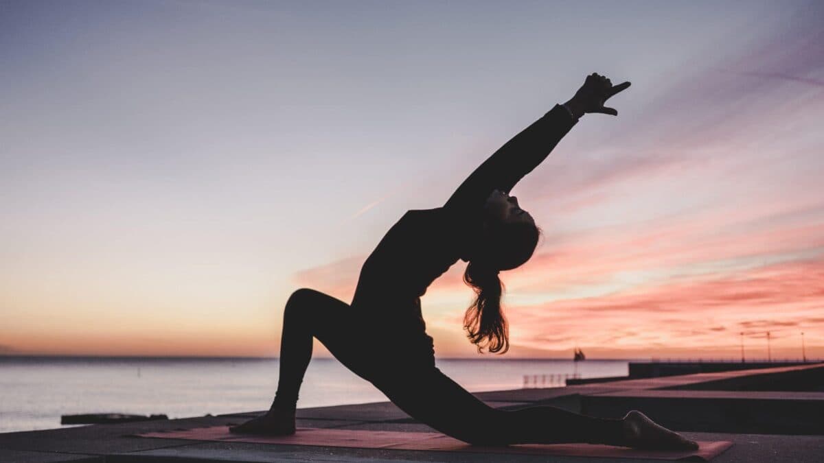 a woman doing yoga on concrete beach