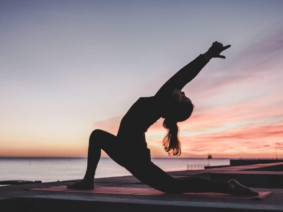 a woman doing yoga on concrete beach