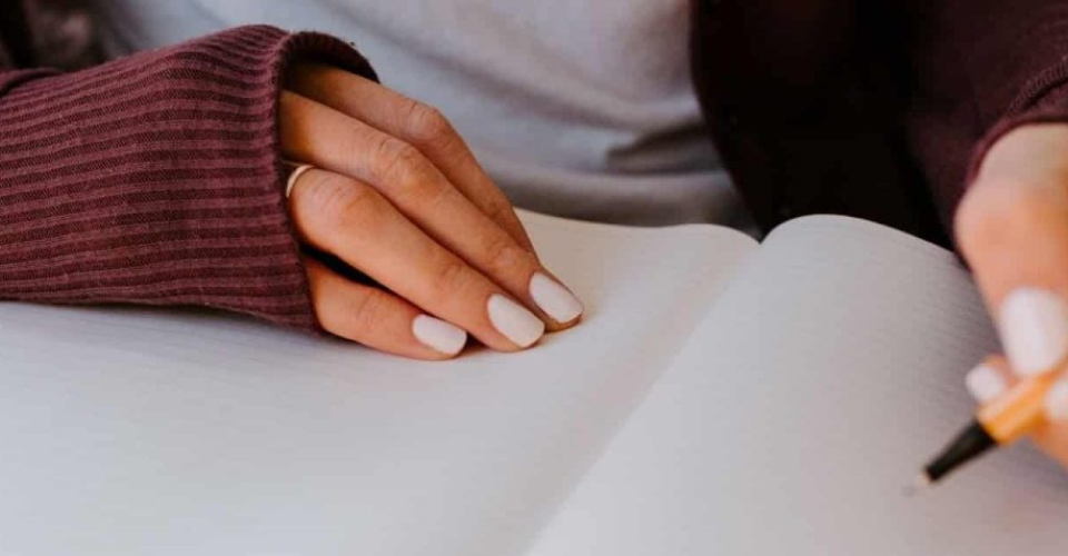 woman writing something on a notebook