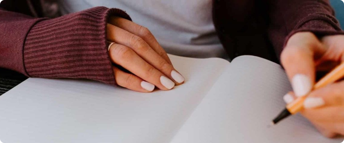woman writing something on a notebook