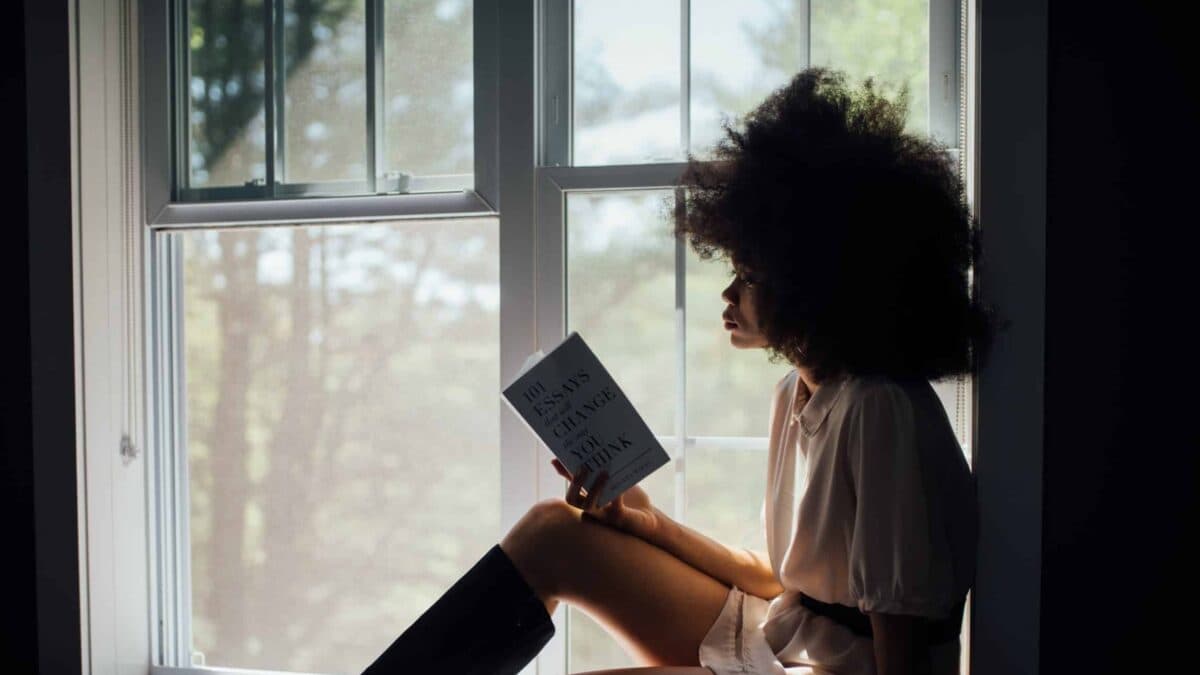 a lady reading book by the window