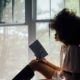 a lady reading book by the window