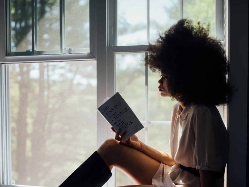 a lady reading book by the window