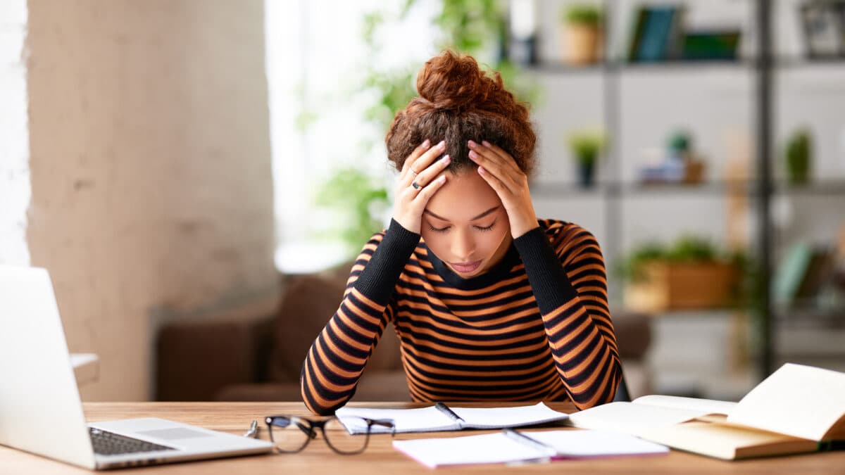 a stressed woman holding her head