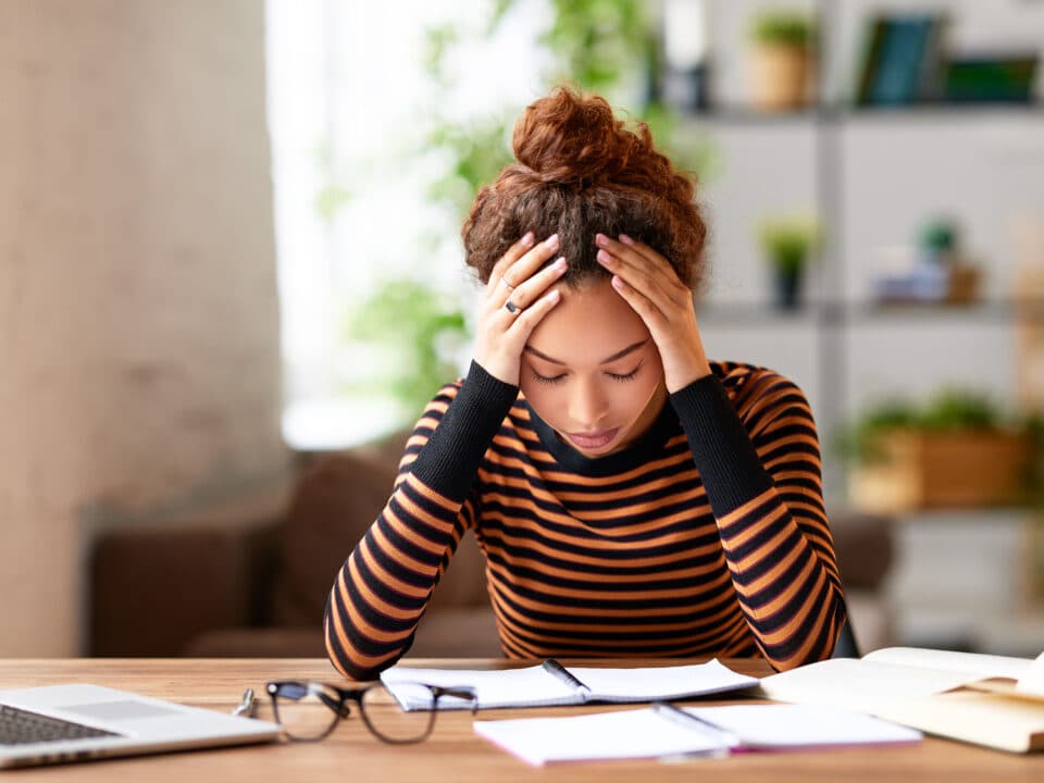 a stressed woman holding her head